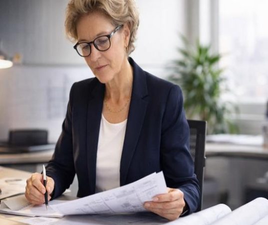 Ingenieurin analysiert LV am Schreibtisch – diskrete Risikoprüfung.